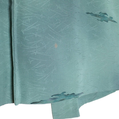 Gros plan sur les motifs de nuages stylisés du haori japonais en soie bleu turquoise grisé.