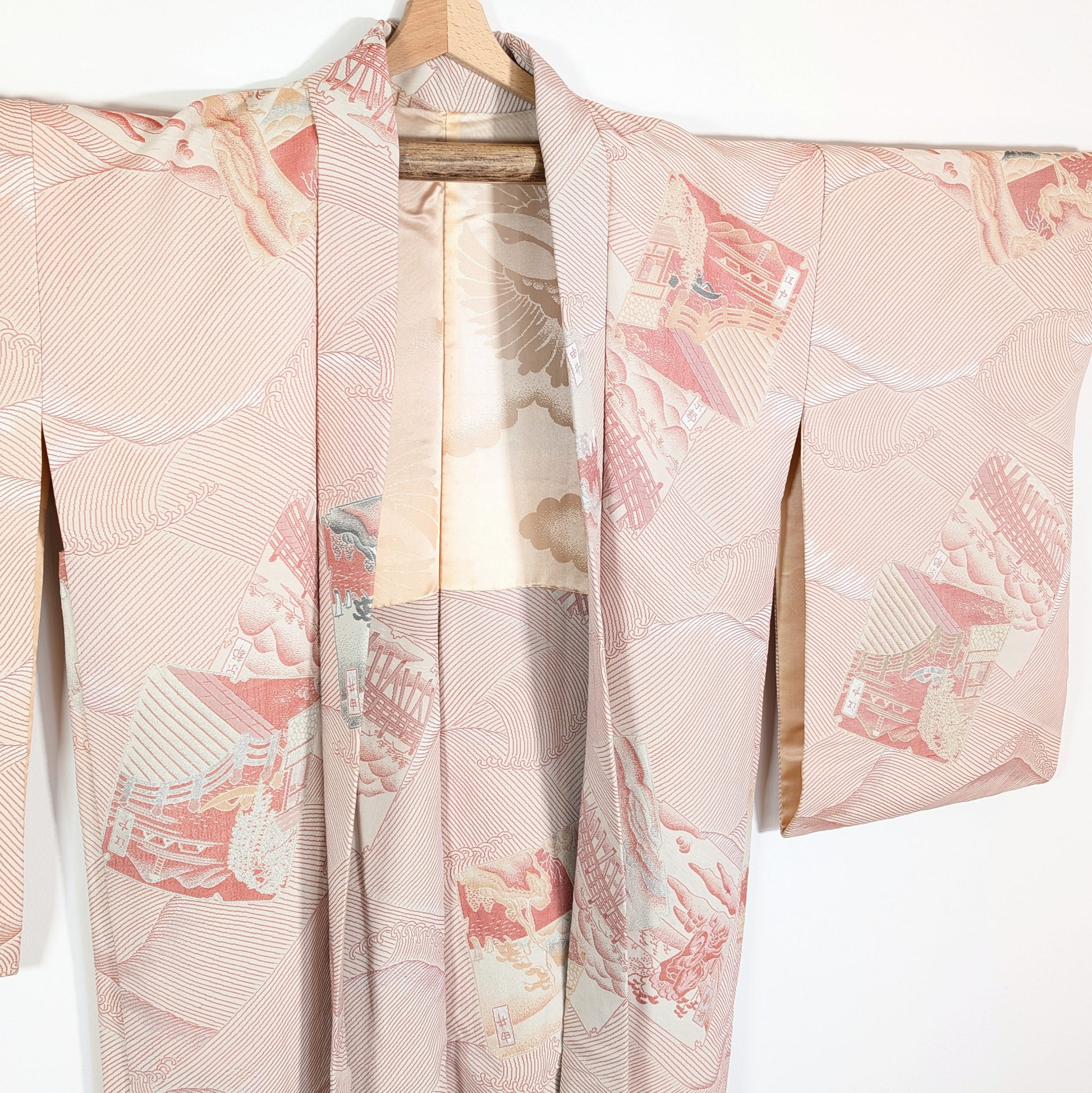 Vue de face du haori en soie brochée rose saumon, décoré de paysages du Tōkaidō, de vagues nami et de détails métallisés