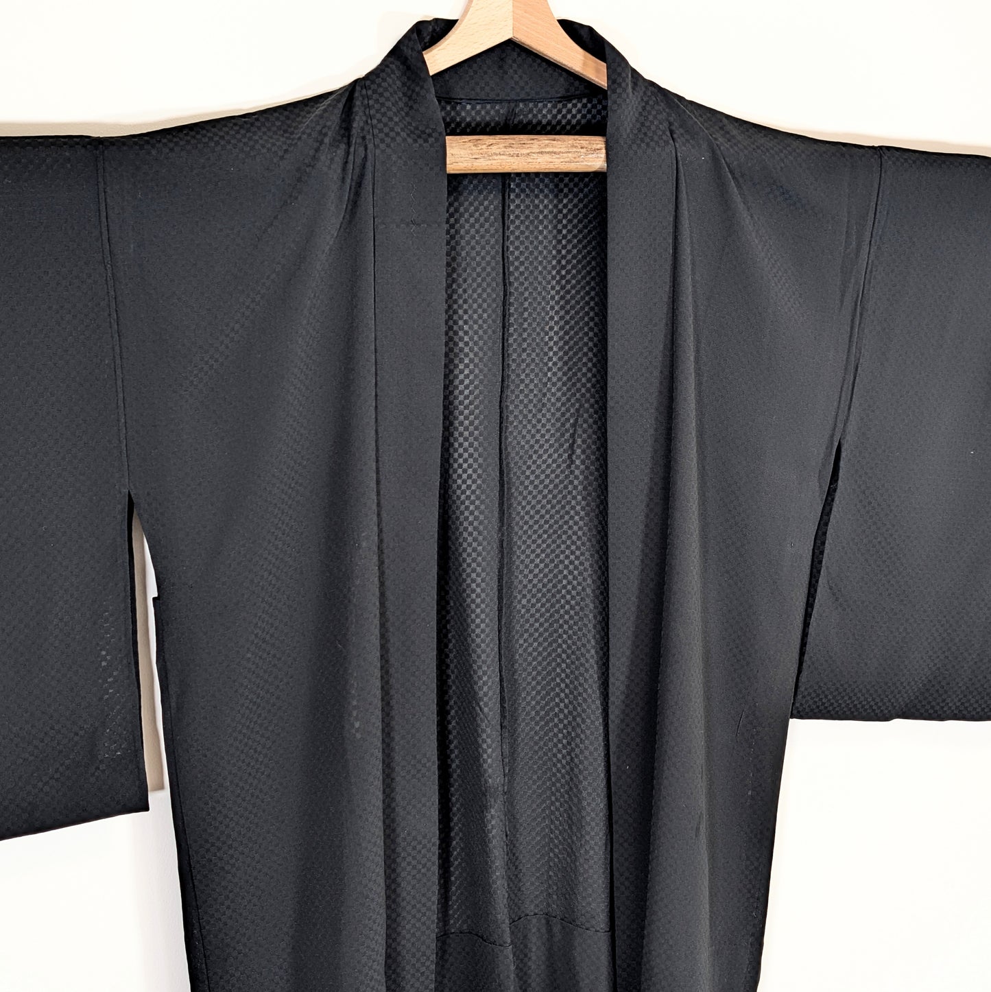 Détail du col d’un haori en soie noire transparente sha, avec motif géométrique ichimatsu tissé ton sur ton.