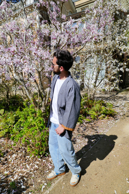  Portrait de Tôma en haori Tradi Tradi devant un magnolia en fleurs, look oversize chic et décontracté.