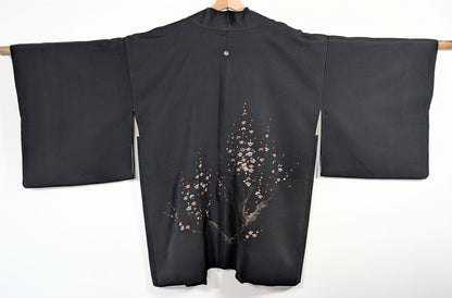 Dos complet d’un haori vintage du Japon en soie noire discrètement brillante, décor de fleurs ume rouges, blanches et dorées.