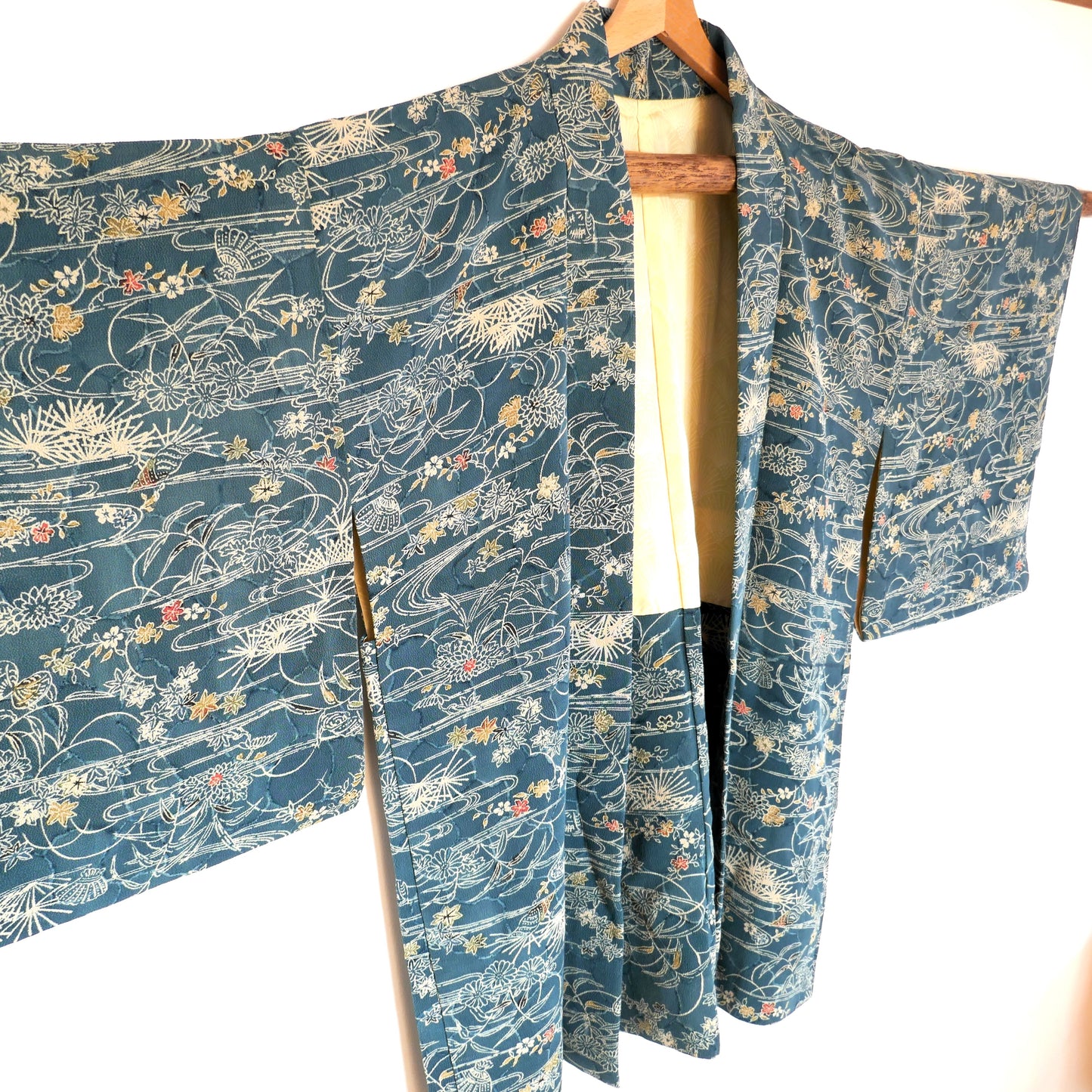 Gros plan sur le haut du haori japonais en soie, avec motifs de coquillages et feuillage – fond blanc