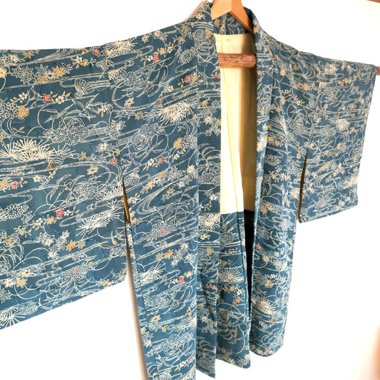 Gros plan sur le haut du haori japonais en soie, avec motifs de coquillages et feuillage – fond blanc