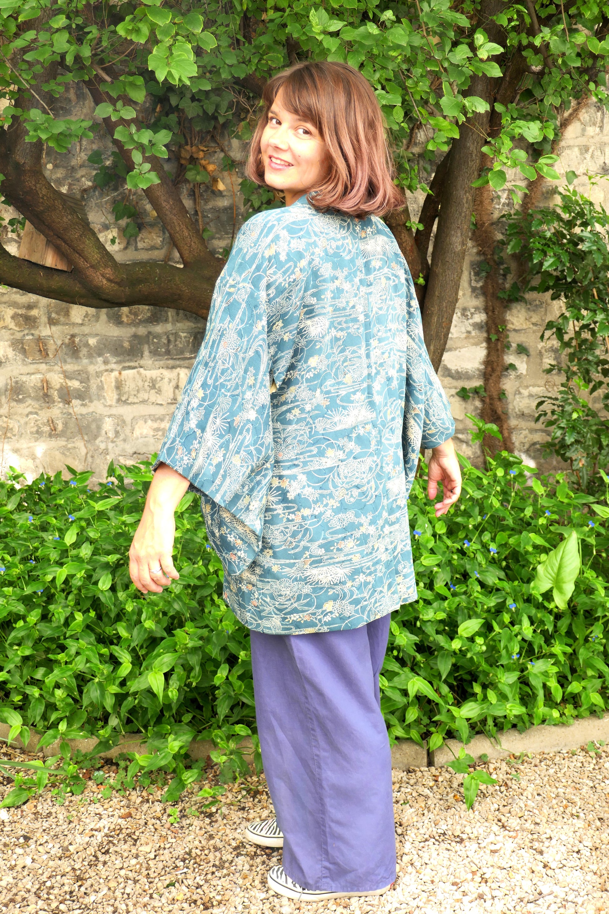 Mikan pose avec un haori japonais en soie, imprimé océanique – look naturel et jardin en arrière-plan