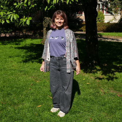 Mikan souriante en veste kimono traditionnelle haori vintage japonais en soie, gris métalisé avec momiji, dans un parc à Paris.
