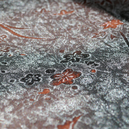 Détail du tissu gris métallisé avec motifs floraux momiji noirs et rouille