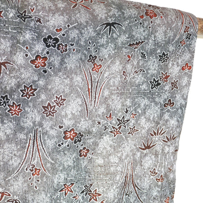 Détail du motif momiji orange et noir sur tissu métallisé gris sur une manche