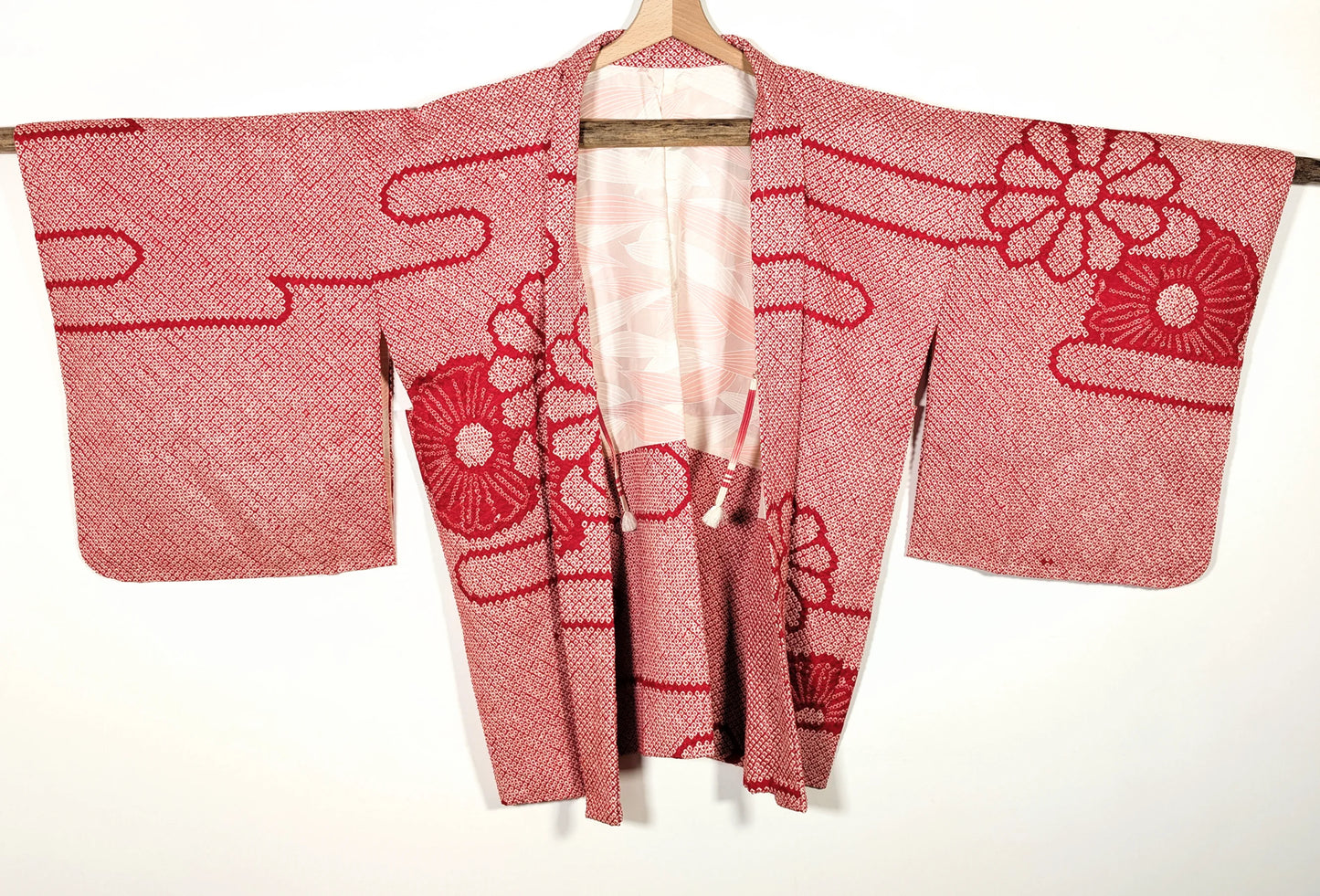 Vue de face d’une veste japonaise haori vintage en soie shibori rouge, motifs traditionnels japonais