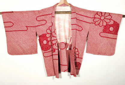 Vue de face d’une veste japonaise haori vintage en soie shibori rouge, motifs traditionnels japonais
