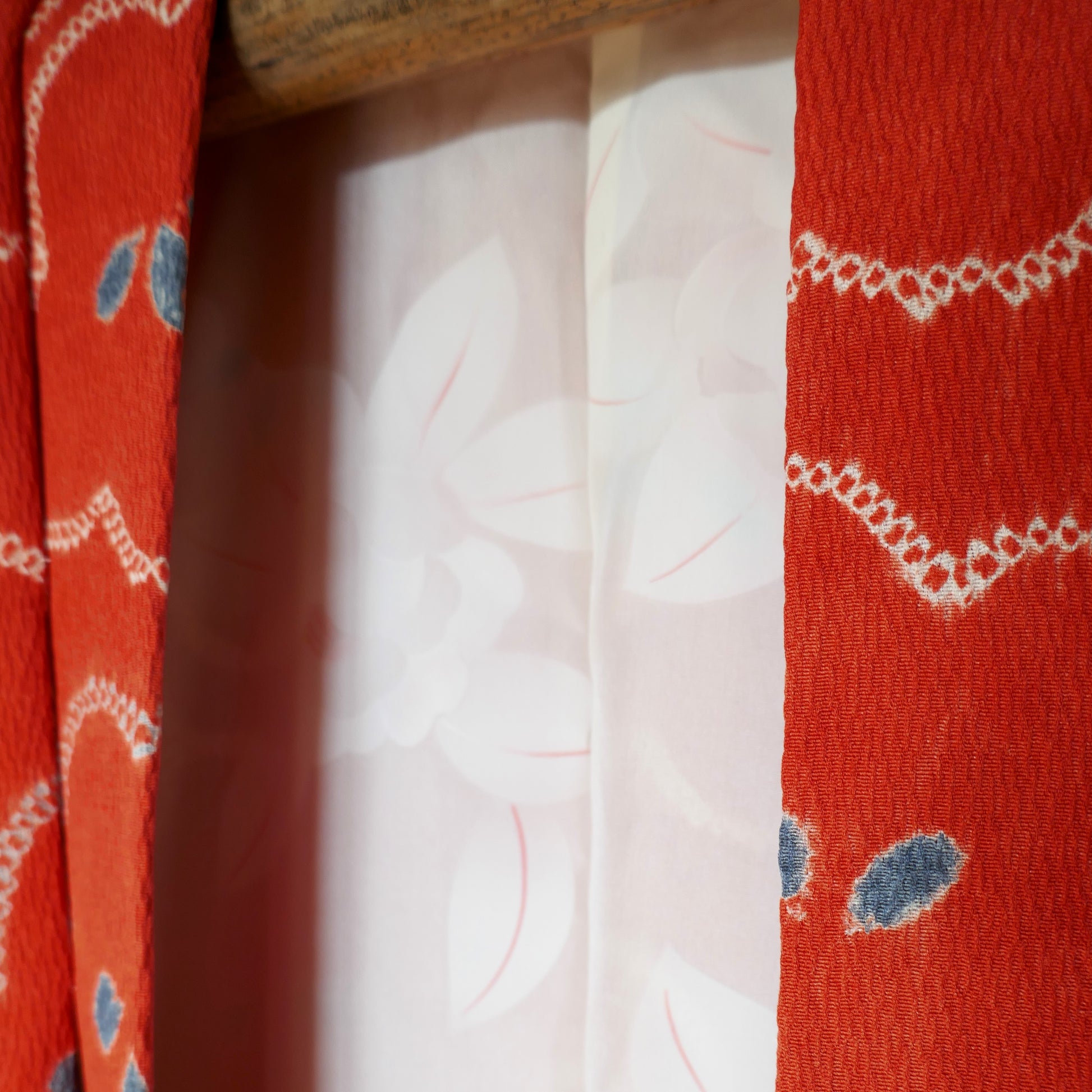 Détail du col du haori montrant le tissu crêpé orange et la doublure florale.