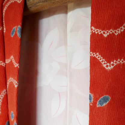 Détail du col du haori montrant le tissu crêpé orange et la doublure florale.
