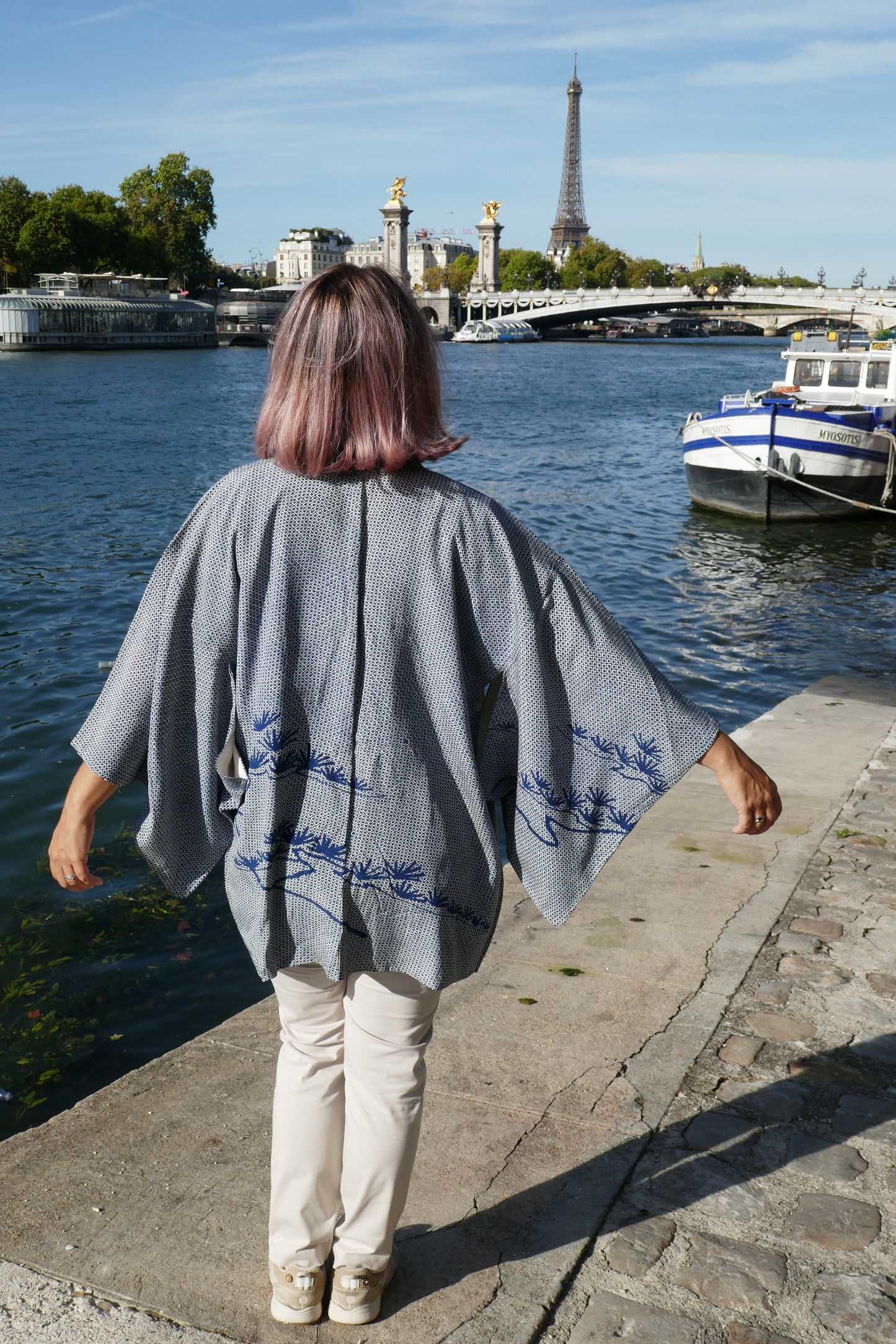 Femme portant un haori vintage en soie, veste kimono traditionnelle japonaise, motif shibori bleu et pin 松 stylisé dans le dos, photo à Paris.