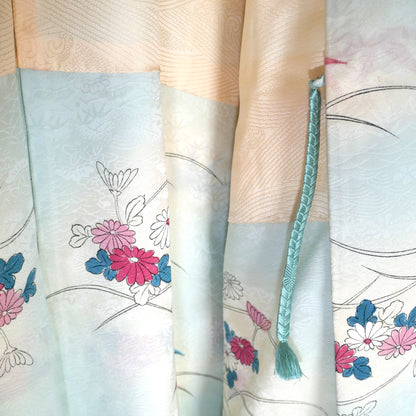 Zoom sur le haori en soie avec attache haori himo vert d’eau et motifs floraux japonais.