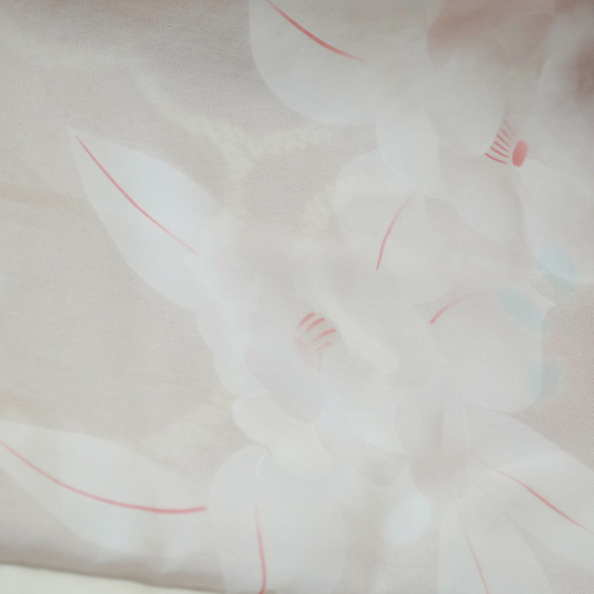  Gros plan de la doublure intérieure du haori avec fleurs blanches tissées sur fond rosé.