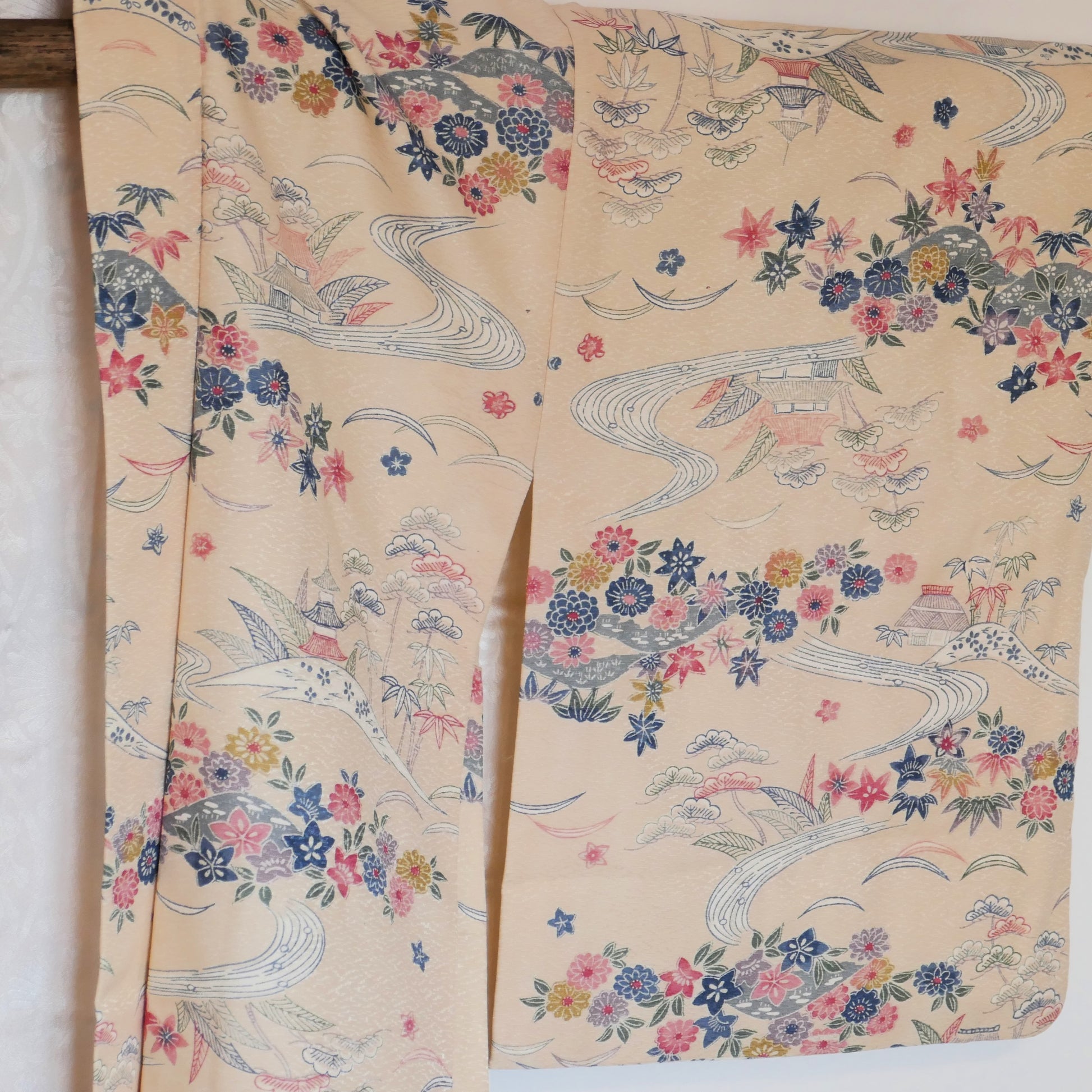 Vue rapprochée de la manche gauche du haori avec motifs de paysages japonais et feuillages.