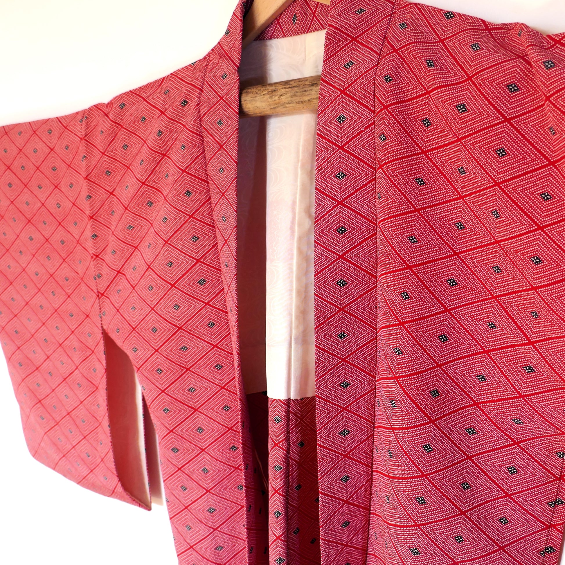 Vue rapprochée du haori vintage rouge à motif losange 菱, mettant en valeur le col, les manches et les détails du tissu