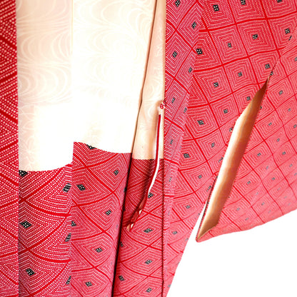 Détail de l’intérieur d’un haori vintage rouge montrant l’attache himo et la doublure en soie ivoire à motifs.