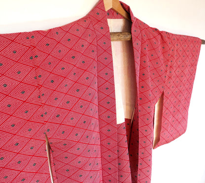  Haori vintage en soie rouge, vu en angle avec détails du motif losange (hishi) et de la doublure intérieure ivoire.
