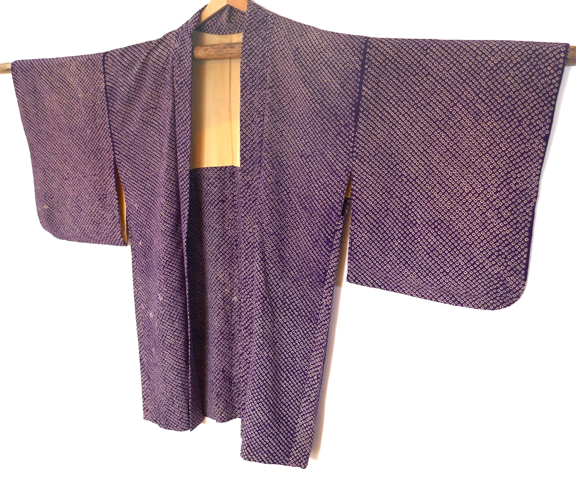 Vue entière d’un haori vintage japonais en shibori violet suspendu sur un cintre
