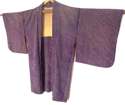 Vue entière d’un haori vintage japonais en shibori violet suspendu sur un cintre