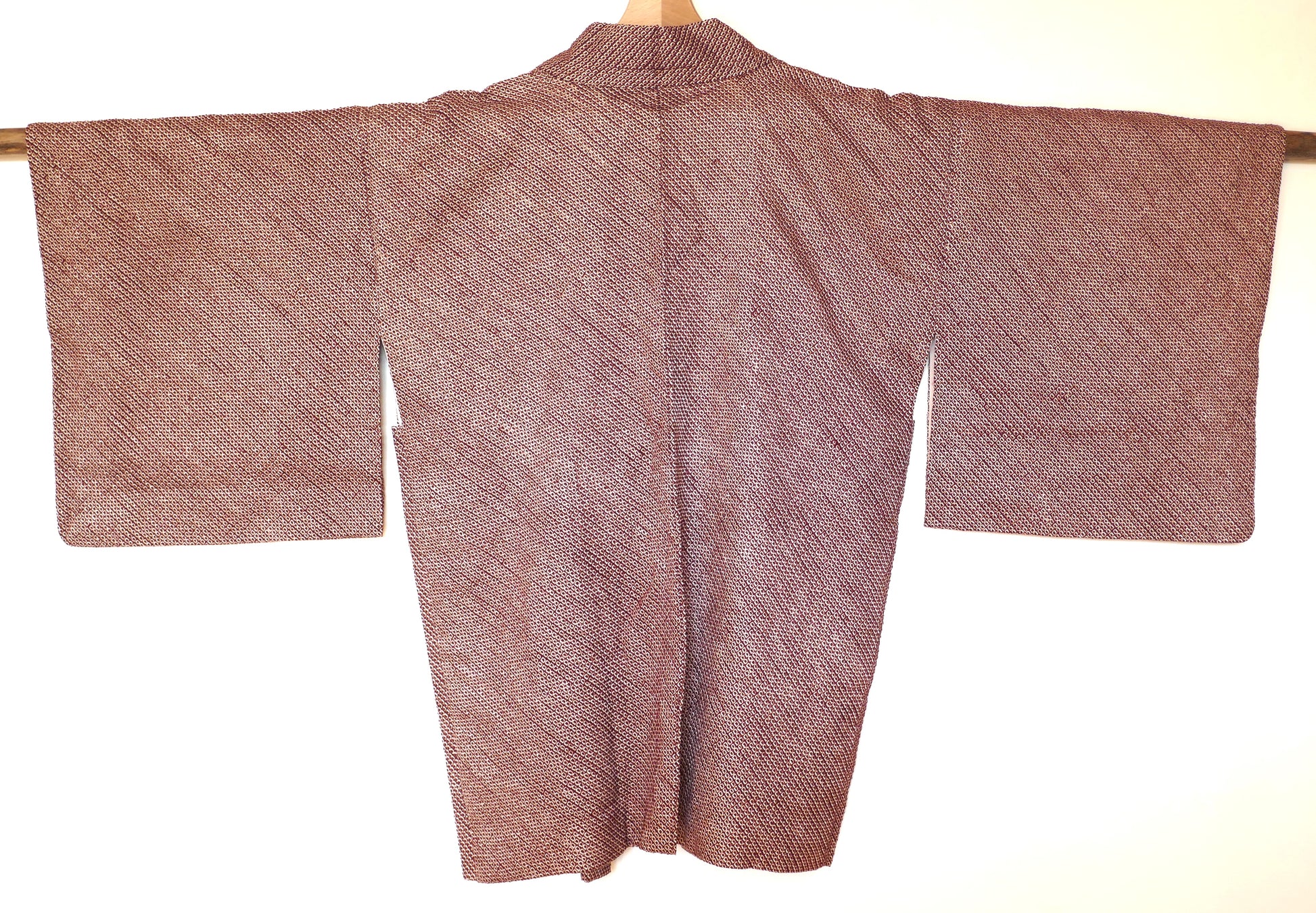 Vue arrière du haori japonais en soie bordeaux avec motif shibori géométrique.