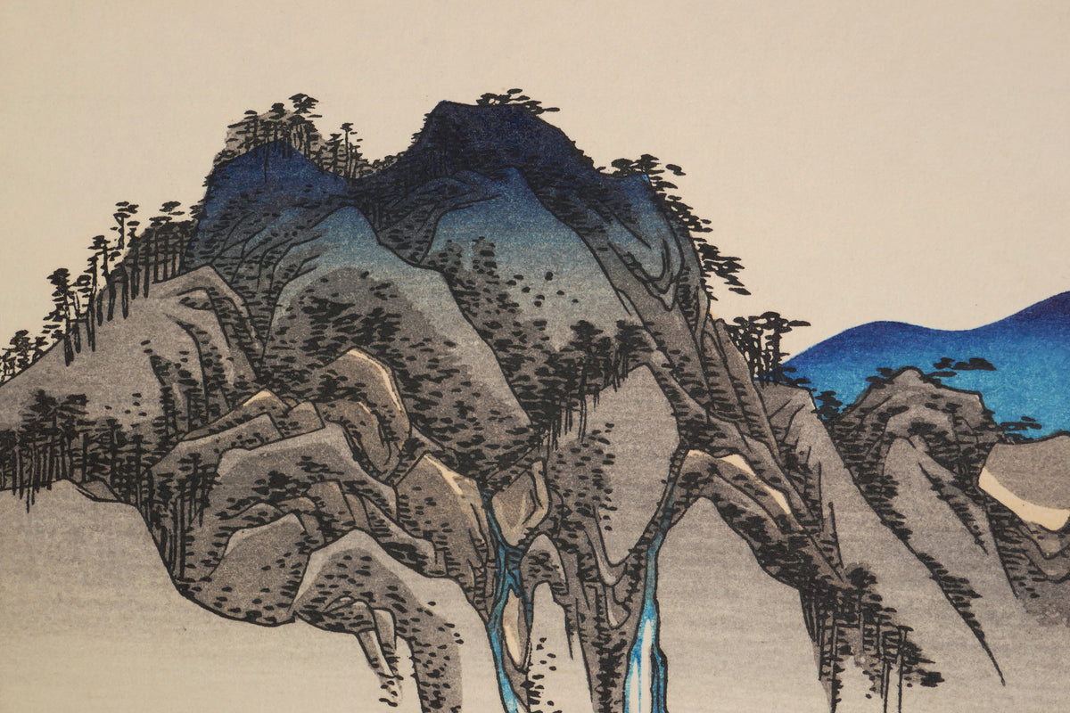 Gros plan du paysage montagneux de Fudesute dans la composition ukiyo-e de Hiroshige, avec superpositions de couleurs de la gravure sur bois.