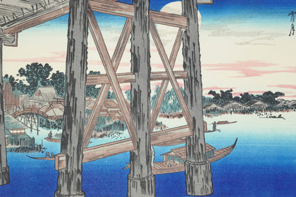 Estampe japonaise représentant la structure en bois du pont Ryōgoku au crépuscule avec une pleine lune en arrière-plan, réalisée par Hiroshige. On y voit des barques sur la rivière et des habitations en arrière-plan. Reproduction Takamizawa, époque Shōwa.