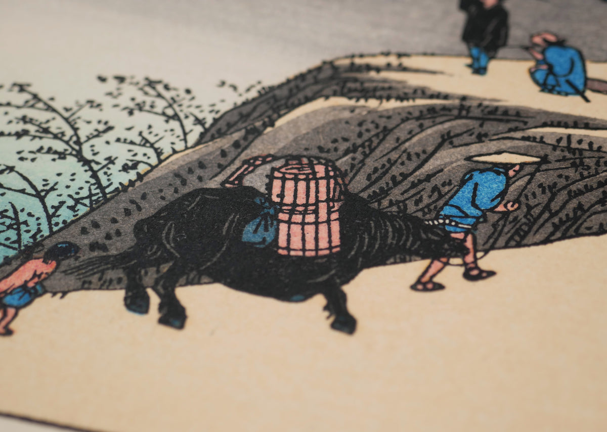 Gros plan du bœuf de bât et des voyageurs sur la route du Tōkaidō dans Sakanoshita, célèbre paysage d’Utagawa Hiroshige.