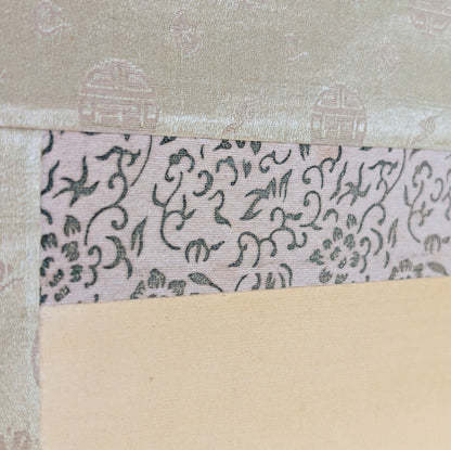 Détail de l’ichimonji à motifs floraux entre le honshi et le brocart de soie du montage hyōsō.