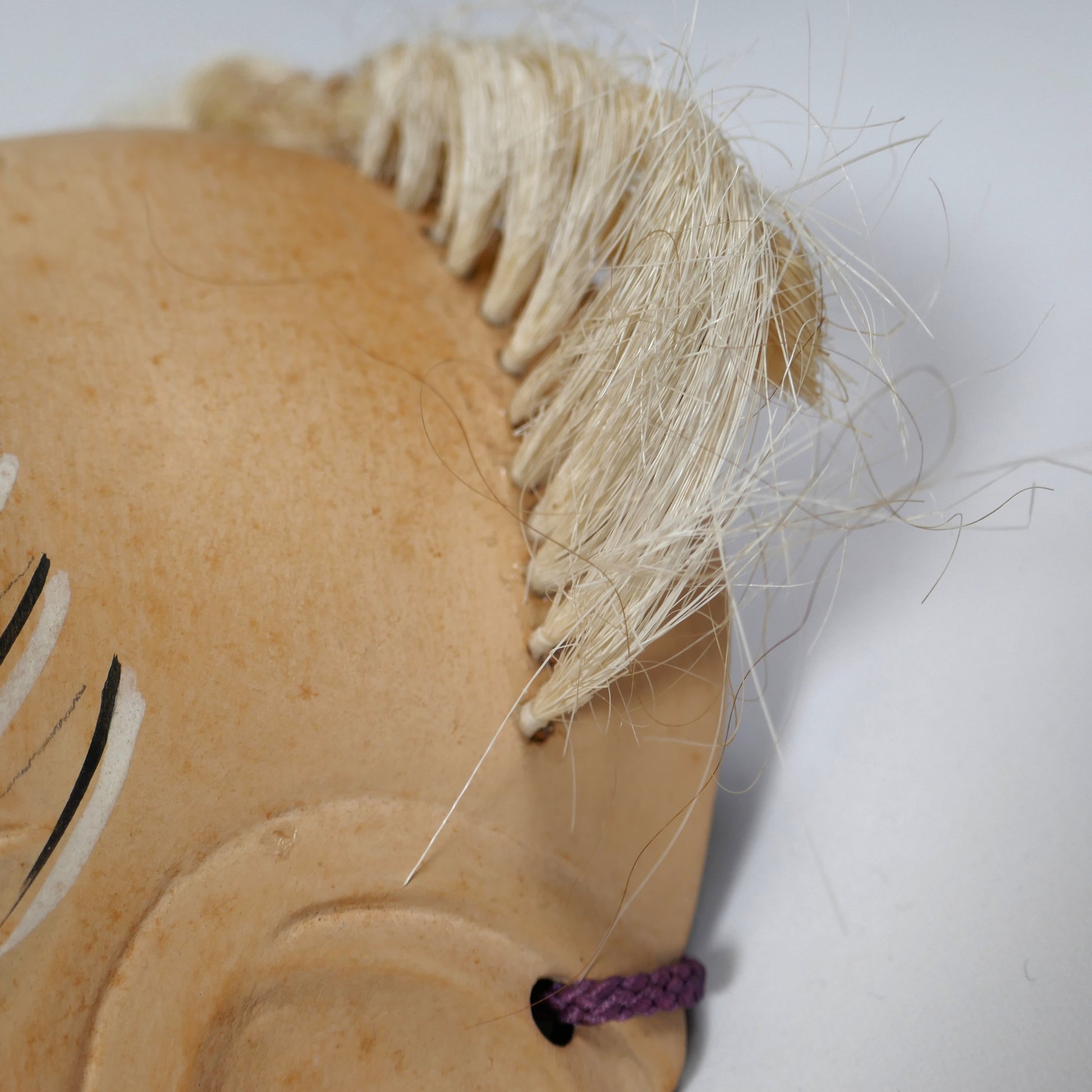 Cheveux en crin naturel implantés à la main sur un masque japonais de Nô, travail artisanal traditionnel.