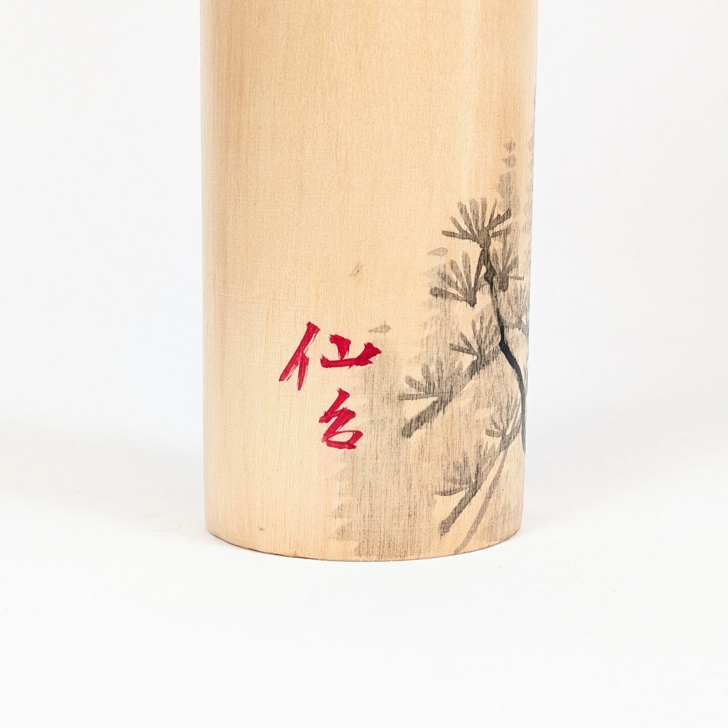 Détail de l’inscription rouge 仙台, Sendai, peinte sur le corps de la kokeshi japonaise signée Shūhō.