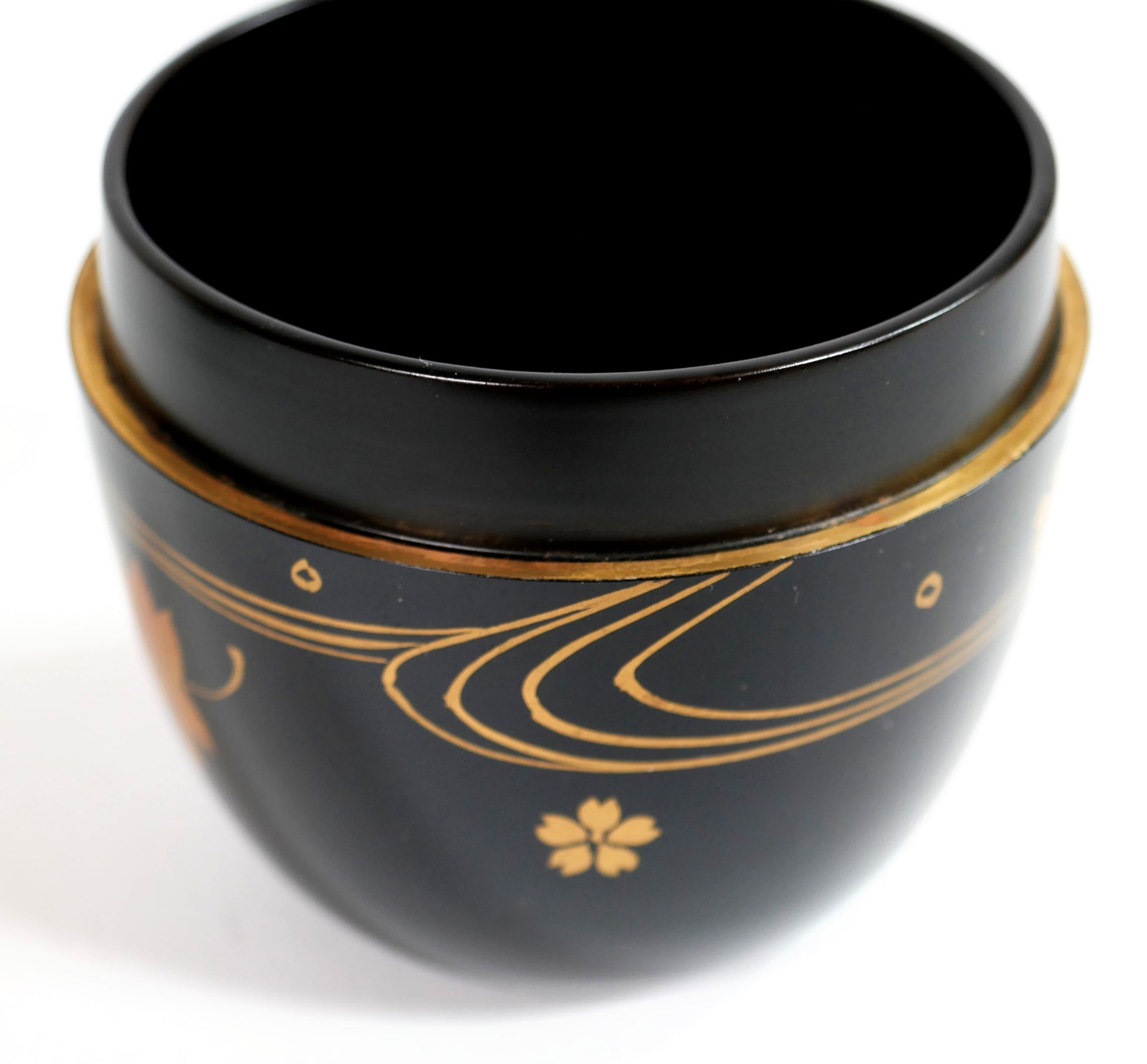 Intérieur d’une boîte à matcha japonaise en laque noire, chū-natsume décoré de lignes d’eau et fleurs en maki-e