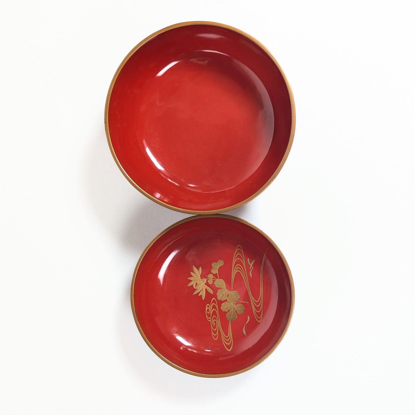 Intérieur rouge du bol japonais et revers du couvercle décoré en maki-e d’un motif kikusui de chrysanthème et eau.