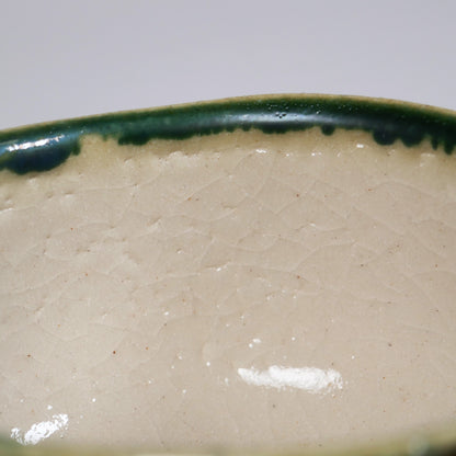 Intérieur du bol matcha Oribe avec émail craquelé crème et bord vert au cuivre, poterie japonaise authentique