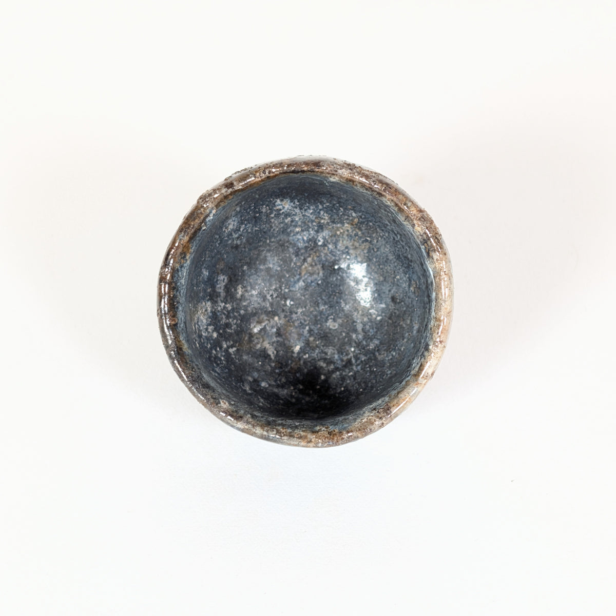 Vue plongeante de l’intérieur d’une coupe à saké Hagi-yaki avec glaçure bleu-gris profonde