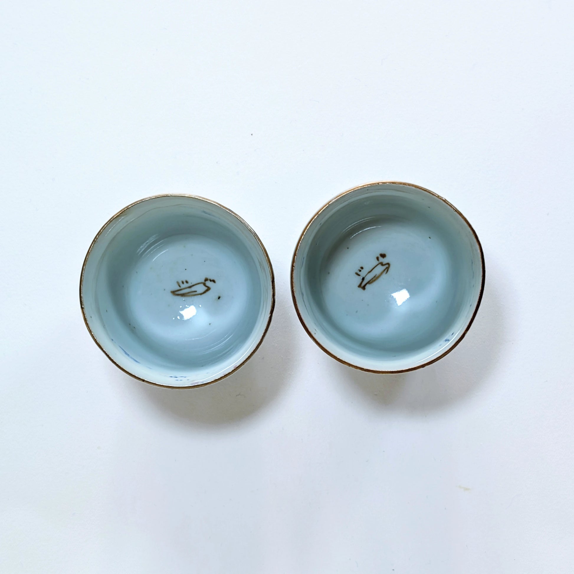 Intérieur de deux guinomi en porcelaine Arita, émail bleu céladon avec petit décor interne, Edo tardif.