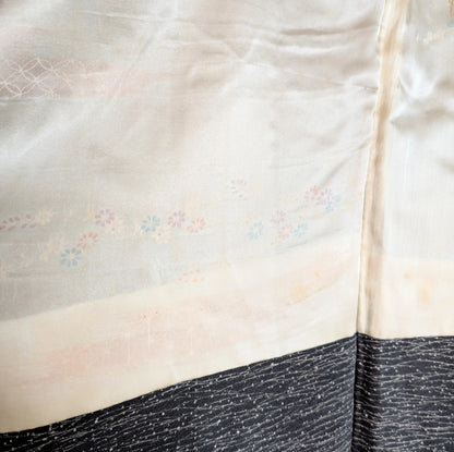 Gros plan sur la doublure en soie blanche à motifs floraux pastel d’un haori japonais ancien