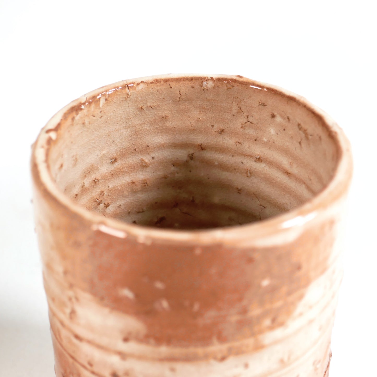 Intérieur d’une tasse yunomi Hagi-yaki pour thé japonais, émail craquelé beige rosé et traces de tournage artisanal
