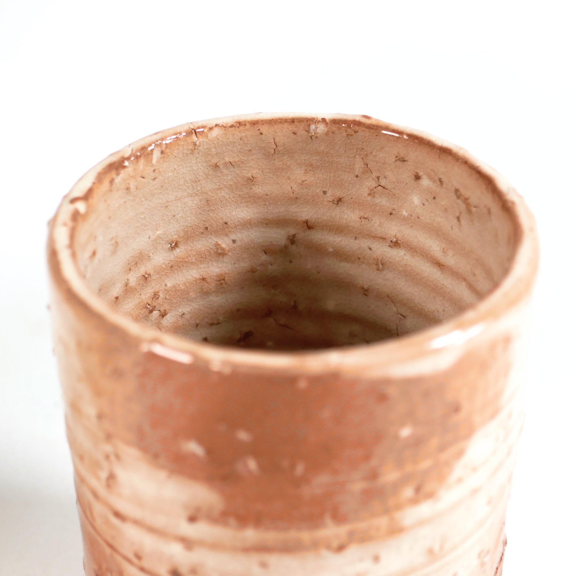Intérieur d’une tasse yunomi Hagi-yaki pour thé japonais, émail craquelé beige rosé et traces de tournage artisanal