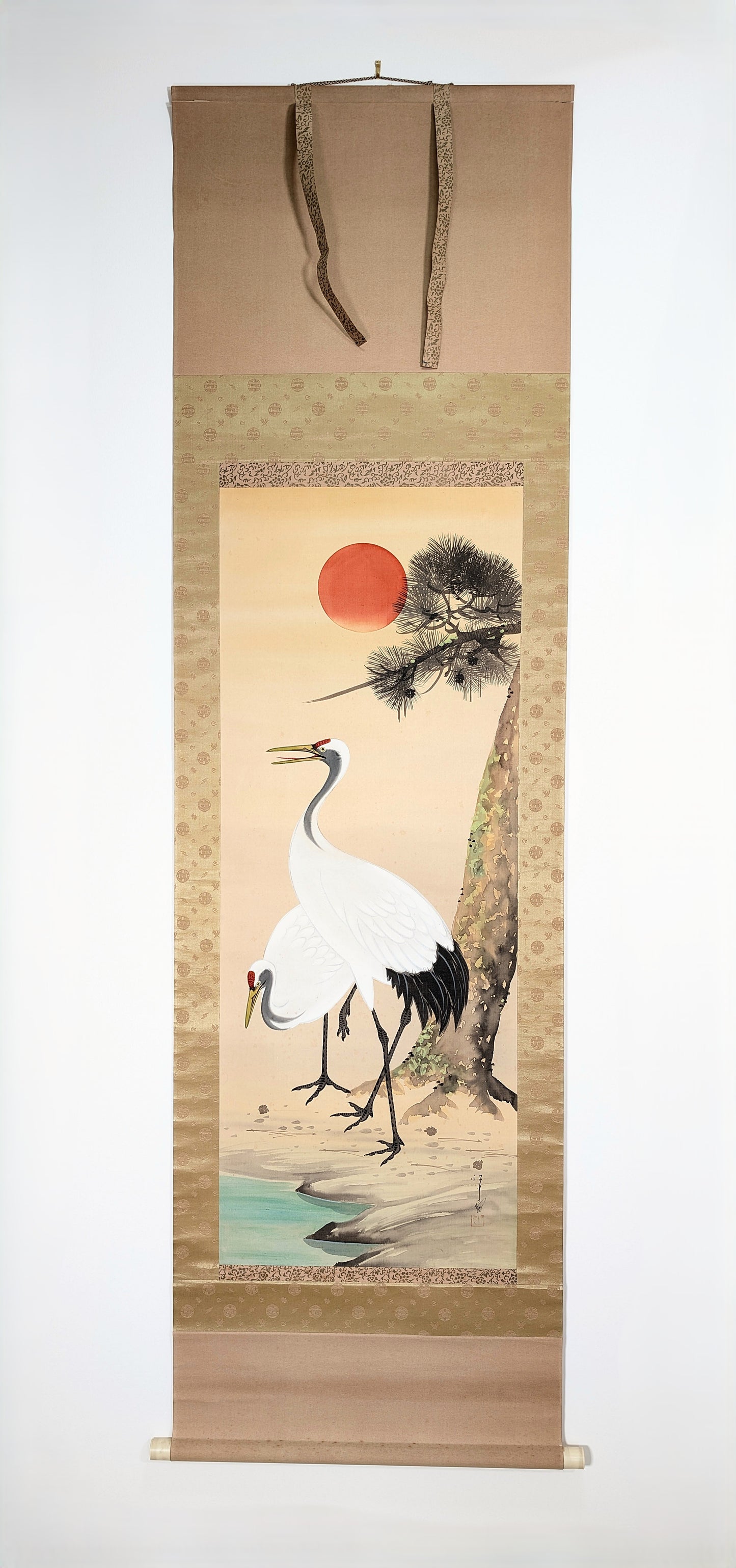 Kakejiku japonais du XXe siècle, probablement époque Shōwa, représentant deux grues sous un pin et un soleil rouge, peinture signée à la main sur soie avec montage en brocart de soie.