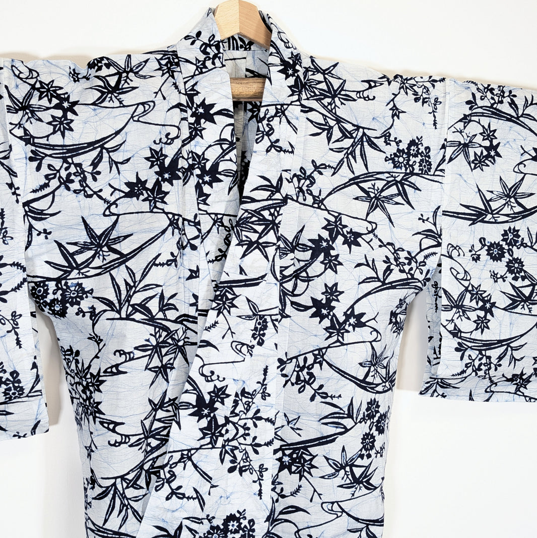 Vue de face d’un yukata japonais blanc à motifs végétaux bleus, érables momiji et bambou stylisé