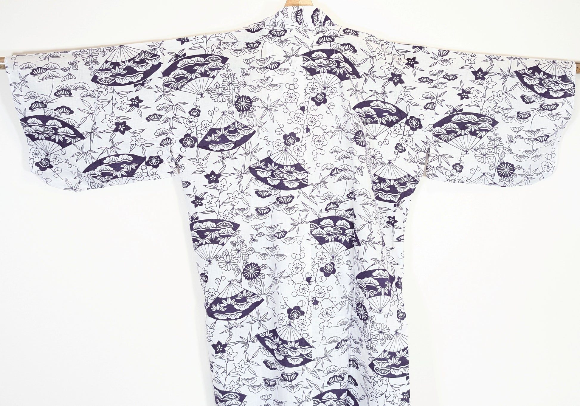 Vue de dos d’un kimono léger japonais femme en coton, imprimé blanc et violet avec éventails sensu, pins matsu, bambous take et fleurs japonaises