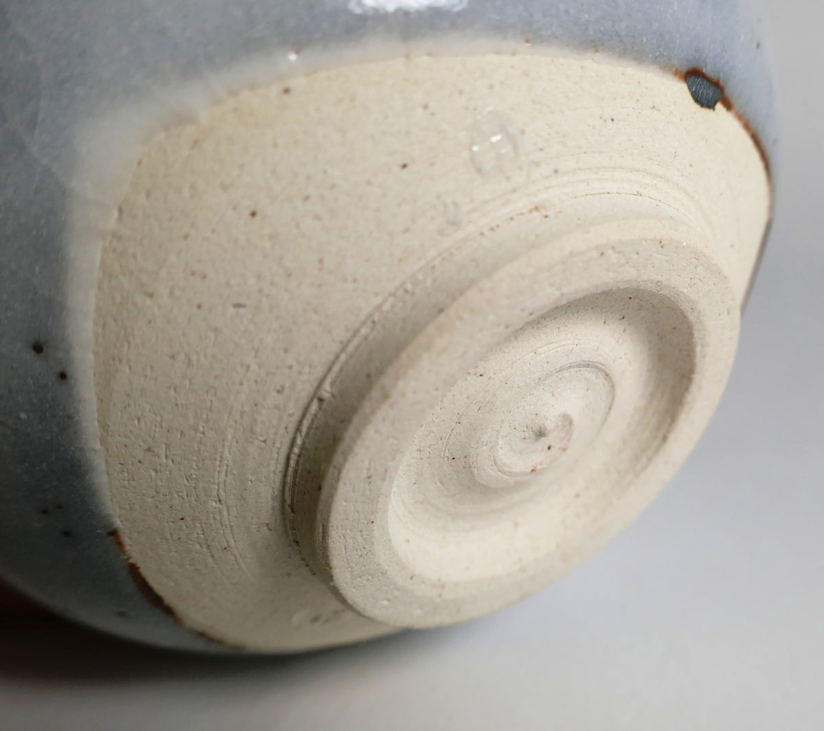 Détail du kōdai tourné et de la terre claire du chawan Shino, témoignant de sa fabrication artisanale japonaise.