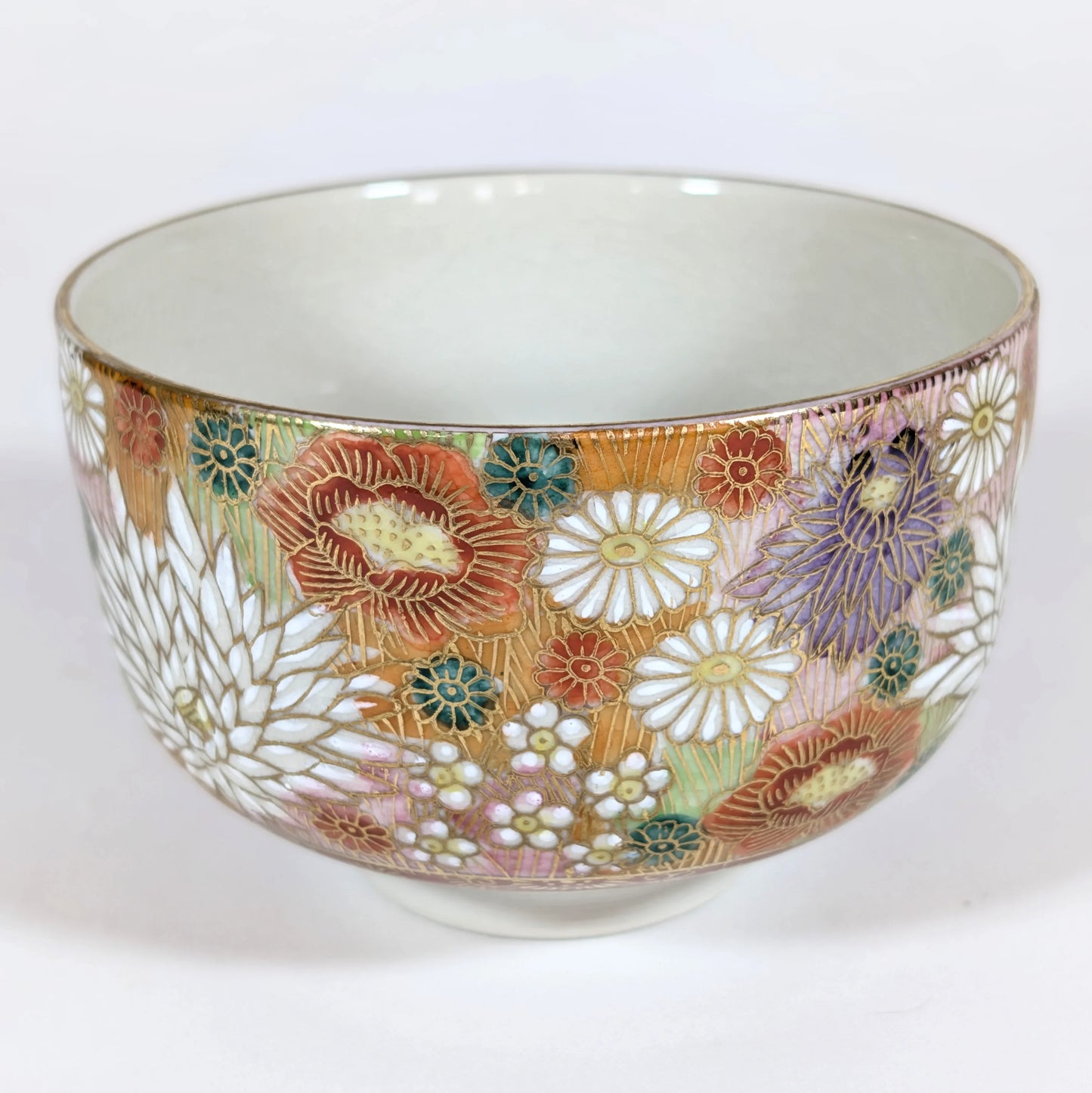 Vue complète d’un bol à thé japonais Kutani signé Seishō (星昭) avec décor floral peint.