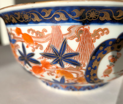 Détail du décor en porcelaine Imari japonaise, poissons rouges nageant parmi érables et montagnes dorées.