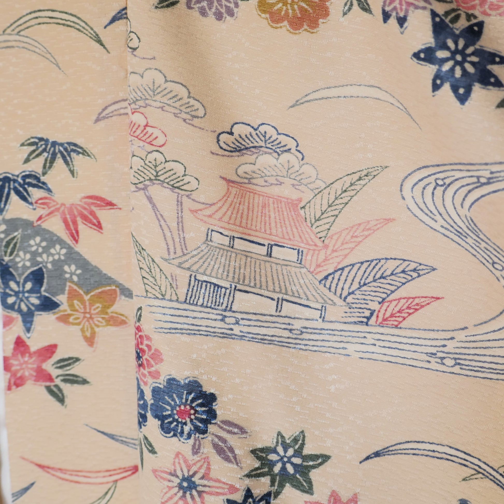 Détail du col du Haori vintage motif cerisiers et temple, fleurs colorées et rivière sinueuse sur fond beige.