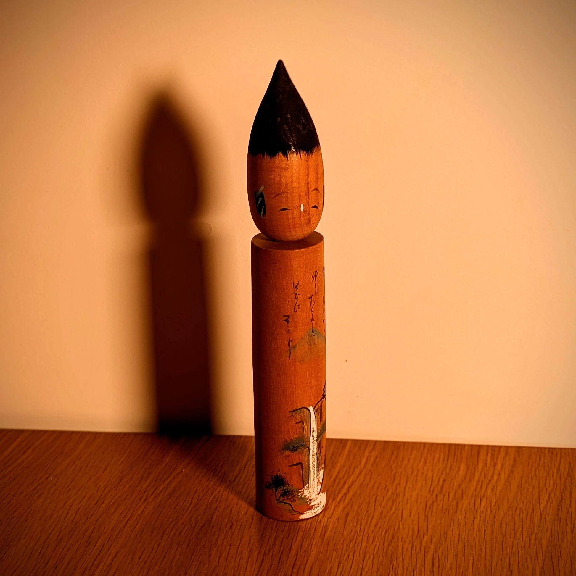 Mise en scène décorative : fude kokeshi japonaise vintage, esprit wabi-sabi, silhouette élancée et ombre portée, objet d’art populaire.