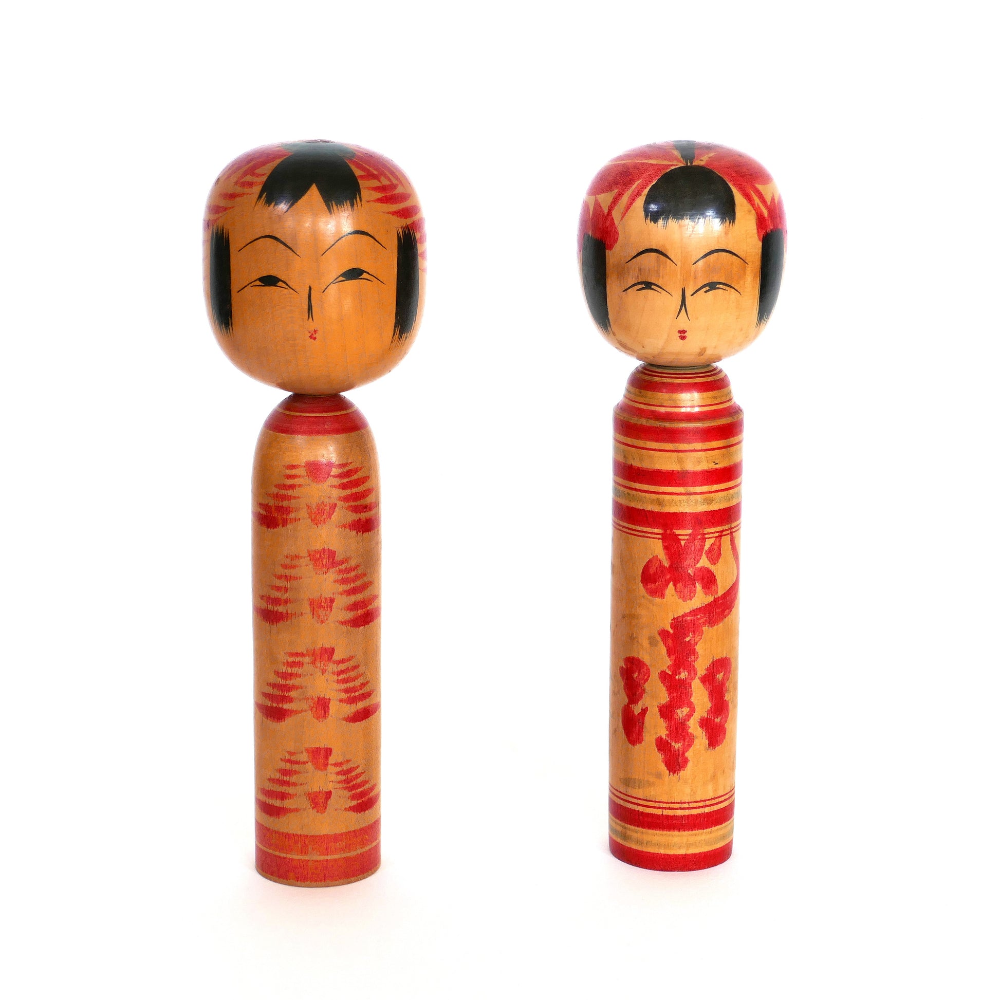 Deux kokeshi japonaises alignées face à l’objectif, styles Togatta et Sakunami.