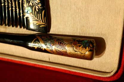 Détail du manche du kogai d’époque Edo, orné de fleurs en nacre irisée et de motifs dorés sur fond laqué noir.