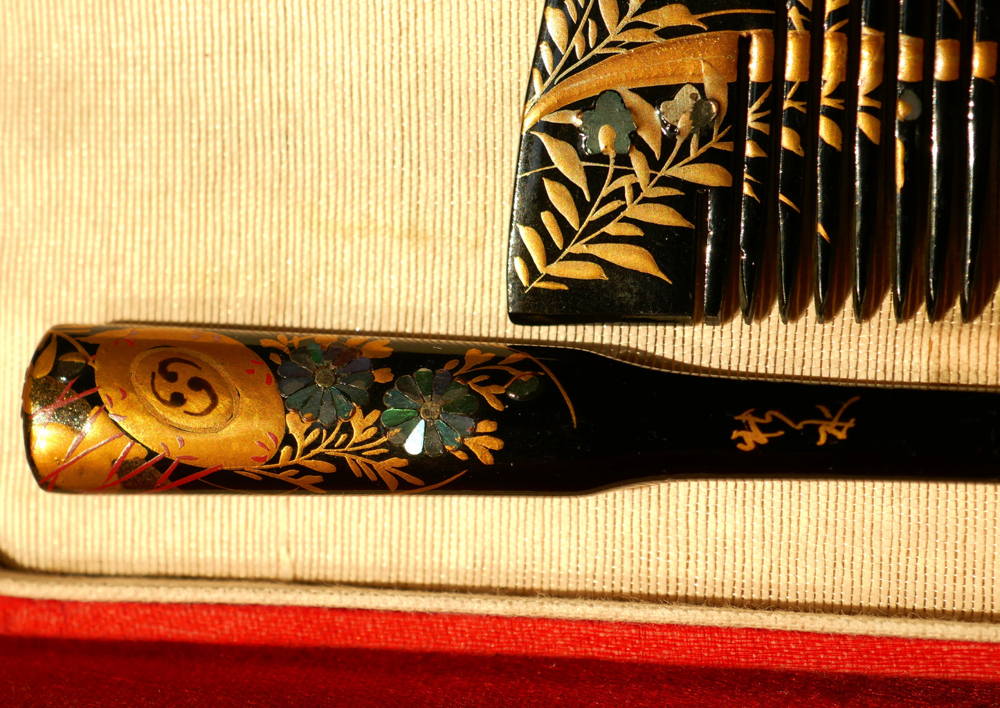 Détail du manche du kogai kogedo montrant les incrustations en nacre et la dorure en maki-e sur un décor végétal raffiné.